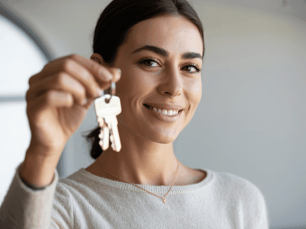 זוג צעיר מחזיק מפתחות בידיים ומחייך